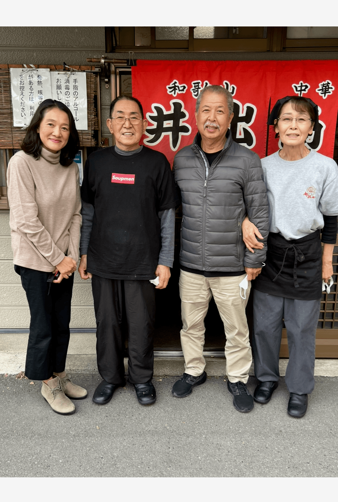 Four people standing in front of the Ide Shoten storefront in Wakayama, Japan: from left, Koji Takeda's wife, Ide Norio, Koji Takeda, and Norio's wife.